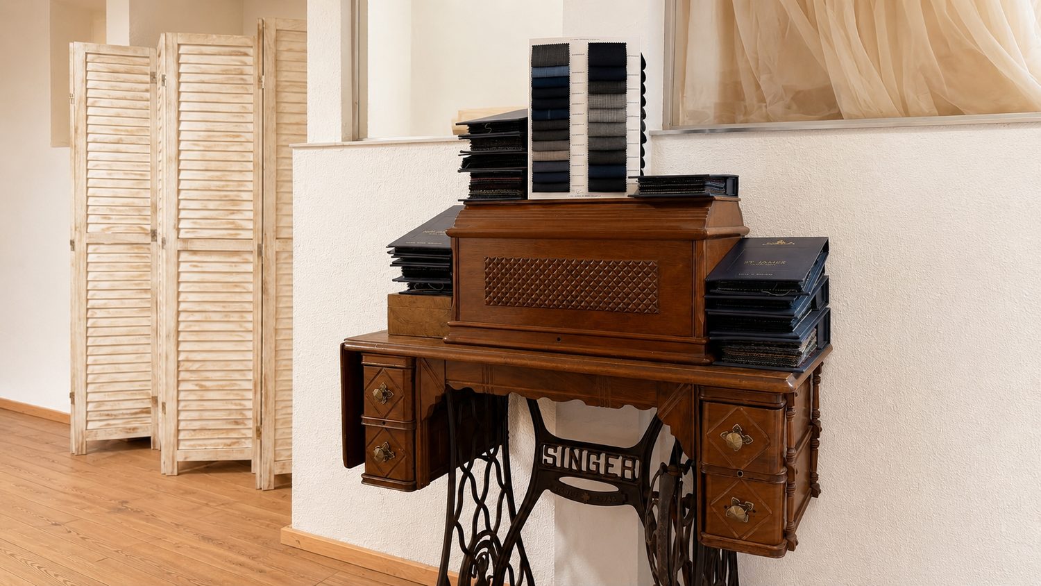 Antike Singer-Nähmaschine mit Stoffmusterbüchern im Atelier Rikelmys